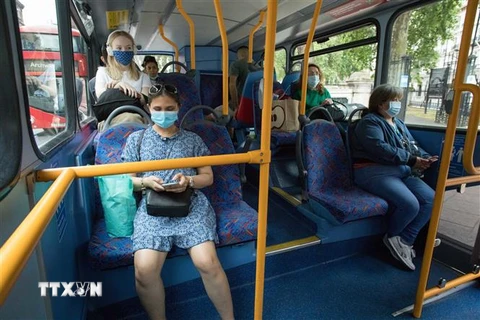 Người dân đeo khẩu trang phòng lây nhiễm COVID-19 trên xe buýt tại London, Anh ngày 15/6/2020. (Nguồn: THX/TTXVN) 