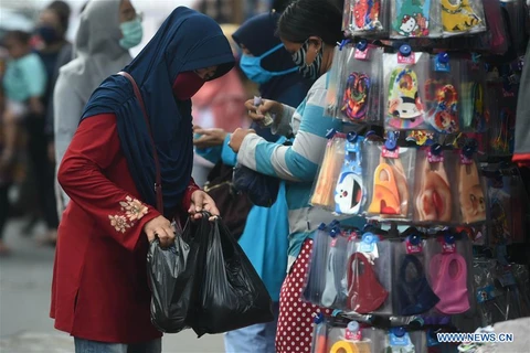 Một phụ nữ mang túi nylon tại một khu chợ ở Jakarta, Indonesia, ngày 30/6/2020. (Nguồn: Tân Hoa xã) 