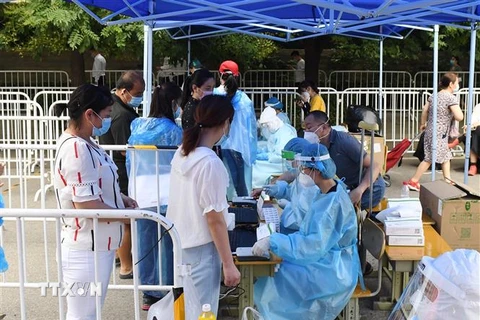 Nhân viên y tế lấy mẫu dịch xét nghiệm COVID-19 cho người dân tại Bắc Kinh, Trung Quốc, ngày 26/6/2020. (Nguồn: THX/TTXVN) 