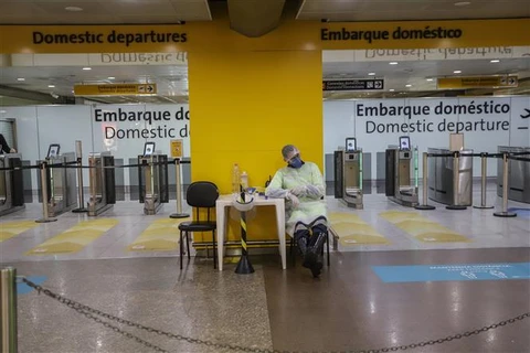 Nhân viên mặc quần áo bảo hộ phòng lây nhiễm COVID-19 tại sân bay quốc tế Guarulhos, ngoại ô Sao Paulo, Brazil ngày 25/5/2020. (Nguồn: THX/TTXVN) 