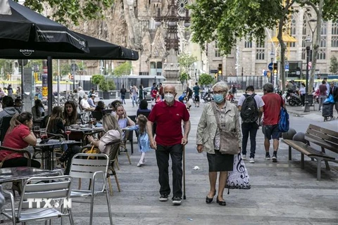 Người dân đeo khẩu trang phòng tránh COVID-19 tại một khu phố ở Barcelona, Tây Ban Nha. (Nguồn: THX/TTXVN) 