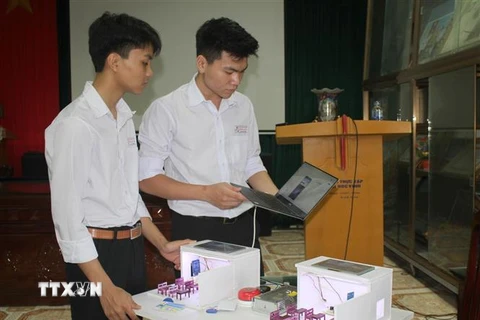 Học sinh Đào Thái Bình Dương và Nguyễn Quang Huy hoàn thiện sáng kiến. (Ảnh: Thùy Dung/TTXVN) 