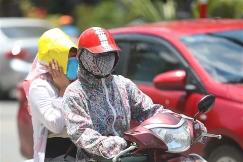 Thời điểm giữa trưa, nếu phải di chuyển trên đường, người dân cần trang bị đồ chống nắng để đảm bảo sức khỏe. (Ảnh: Thanh Tùng/TTXVN) 