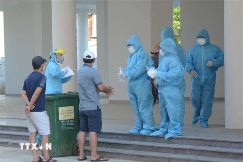 Nhân viên y tế thực hiện quy trình tiếp đón các trường hợp F1 được cách ly tại Khu ký túc xá phía Tây thành phố Đà Nẵng. (Ảnh: Văn Dũng/TTXVN) 