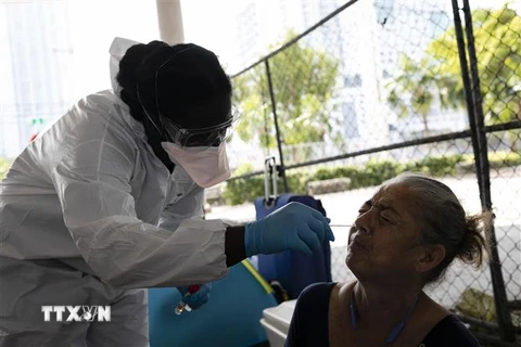 Nhân viên y tế lấy mẫu dịch xét nghiệm COVID-19 cho người dân tại Miami, bang Florida, Mỹ ngày 16/4/2020. (Nguồn: AFP/TTXVN) 