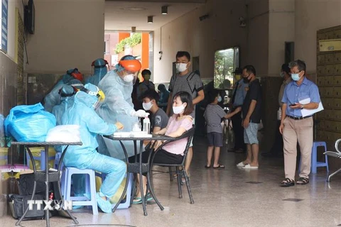Lực lượng y tế túc trực để lấy mẫu xét nghiệm cho toàn bộ cư dân chung cư Thái An 2B, đường Nguyễn Văn Quá, phường Đông Hưng Thuận, Quận 12. (Ảnh: Đinh Hằng/TTXVN) 