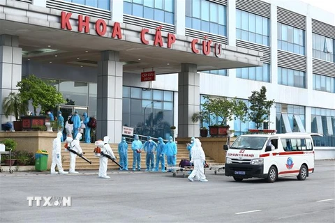 Lực lượng y tế phun thuốc khử khuẩn các công dân khi được đưa về Bệnh viện Nhiệt đới Trung ương cơ sở 2. (Ảnh: Minh Quyết/TTXVN) 