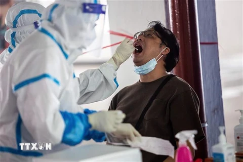 Nhân viên y tế lấy mẫu dịch xét nghiệm COVID-19 cho người dân tại Hong Kong, Trung Quốc ngày 19/7/2020. (Nguồn: AFP/TTXVN) 
