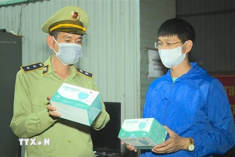 Cán bộ Phòng Cảnh sát giao thông Công an tỉnh Đắk Lắk kiểm tra số khẩu trang y tế không rõ nguồn gốc. (Nguồn: TTXVN) 