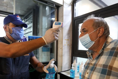 Kiểm tra thân nhiệt phòng lây nhiễm COVID-19 trước khi vào một trung tâm thương mại ở Baghdad, Iraq, ngày 13/8/2020. (Nguồn: THX/TTXVN)