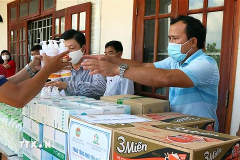 Các doanh nghiệp và nhà hảo tâm trao tặng nhu yếu phẩm thiết yếu cho các đơn vị làm nhiệm vụ phòng, chống dịch COVID-19 ở Quảng Nam. (Ảnh: Trần Tĩnh/TTXVN) 