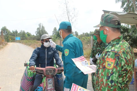Lực lượng Bộ đội biên phòng tuyên truyền về các biện pháp phòng, chống dịch bệnh COVID-19 cho người dân trên vùng biên giới. (Ảnh: Văn Khương/TTXVN)