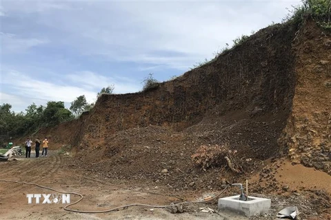Khu đồi đất bị san ủi gần hết để lập bến bãi đỗ xe tải. (Ảnh: Phạm Cường/TTXVN) 