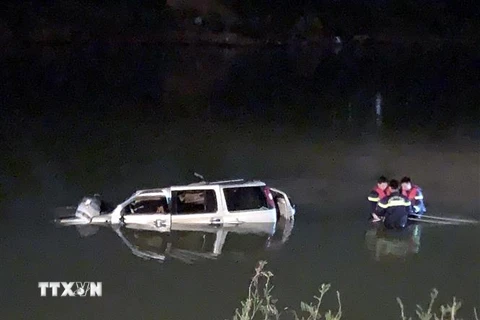 Lực lượng cứu hộ trục vớt chiếc xe ôtô 7 chỗ cùng các thi thể nạn nhân trong đêm. (Nguồn: TTXVN phát) 