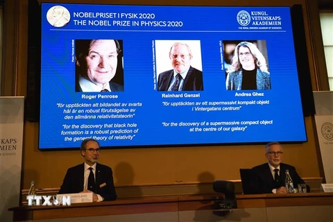 Chân dung ba nhà khoa học (trên màn hình, từ trái sang): Roger Penrose (người Anh), Reinhard Genzel (người Đức) và Andrea Ghez (người Mỹ) được xướng tên đoạt giải Nobel Vật lý 2020 tại buổi lễ ở Viện Hoàng gia Thụy Điển, thủ đô Stockholm ngày 6/10/2020. (
