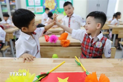 Học sinh lớp 1 trường Tiểu học Thăng Long, quận Hoàn Kiếm bày tỏ sự thích thú với môi trường học mới. (Ảnh: Thanh Tùng/TTXVN) 