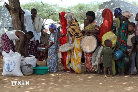 Phân phát lương thực viện trợ của Chương trình Lương thực thế giới (WFP) cho người dân tại trại tị nạn ở Mogadishu, Somalia ngày 16/6/2009. (Nguồn: AFP/TTXVN) 