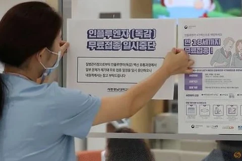 Một nhân viên y tế dán thông báo tạm dừng chương trình tiêm chủng cúm trước cổng một bệnh viện ở Sejong, Hàn Quốc, ngày 22/9/2020. (Ảnh: Reuters / Yonhap) 