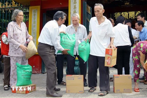 Hội quán Ôn Lăng (của cộng đồng người Hoa) cùng Hội Chữ Thập đỏ Quận 5 tặng quà định kỳ giúp hộ nghèo, người già neo đơn, đóng góp một phần tích cực trong chương trình xóa đói giảm nghèo của địa phương. (Ảnh: Thanh Vũ/TTXVN) 