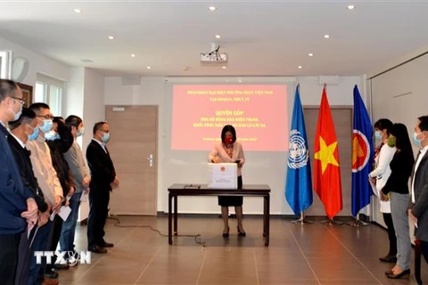 Đại sứ Lê Thị Tuyết Mai cùng các đại diện quyên góp giúp đỡ đồng bào các tỉnh miền Trung bị thiệt hại do mưa lũ. (Ảnh: Tố Uyên/TTXVN) 