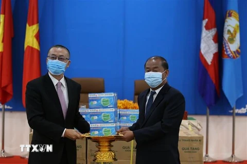 Đại sứ đặc mệnh toàn quyền Việt Nam tại Campuchia Vũ Quang Minh bàn giao quà tặng khẩu trang tới ông Kem Sambath, Ủy viên Trung ương Đảng, Phó Trưởng Ban Đối ngoại Trung ương CPP. (Ảnh: Hùng Vũ/TTXVN) 