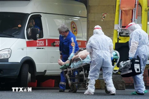 Nhân viên y tế chuyển bệnh nhân nhiễm COVID-19 tới bệnh viện ở Saint Petersburg, Nga. (Nguồn: AFP/TTXVN) 