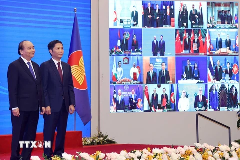 Thủ tướng Nguyễn Xuân Phúc, Chủ tịch ASEAN 2020 và Bộ trưởng Bộ Công Thương Trần Tuấn Anh và các nước tham dự lễ ký Hiệp định Đối tác Kinh tế Toàn diện Khu vực (RCEP). (Ảnh: Thống Nhất/TTXVN) 