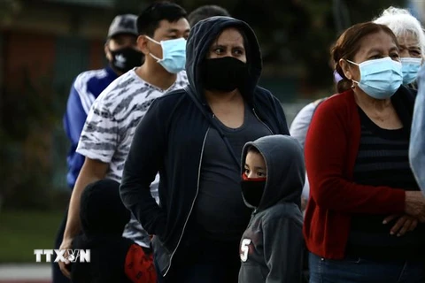 Người dân đeo khẩu trang phòng lây nhiễm COVID-19 khi xếp hàng chờ nhận hàng phân phát tại Los Angeles, California, Mỹ, ngày 19/11/2020. (Nguồn: THX/TTXVN) 