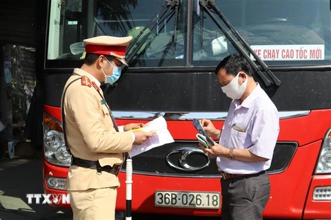 Tổ công tác của Trạm Cảnh sát giao thông Tam Điệp, Phòng Cảnh sát giao thông Công an tỉnh Ninh Bình kiểm tra một xe chở khách trên tuyến Quốc lộ 1A. (Ảnh: Đức Phương/TTXVN) 