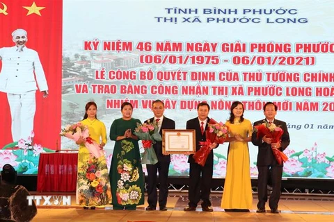 Lãnh đạo tỉnh Bình Phước thừa Ủy quyền trao quyết định của Thủ tướng công nhận thị xã Phước Long hoàn thành nhiệm vụ xây dựng nông thôn mới. (Ảnh: Sỹ Tuyên/TTXVN) 