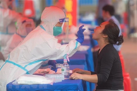 Nhân viên y tế xét nghiệm COVID-19 cho người dân tại Vũ Hán, tỉnh Hồ Bắc, Trung Quốc. (Nguồn: THX/TTXVN) 
