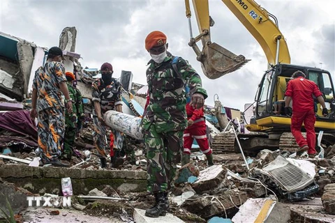 Lực lượng cứu hộ tìm kiếm nạn nhân dưới đống đổ nát sau trận động đất tại tỉnh Tây Sulawesi, Indonesia, ngày 17/1/2021. (Nguồn: THX/TTXVN) 
