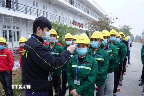 Công nhân, cán bộ thi công đều được kiểm tra thân nhiệt, xét nghiệm trước khi vào công trường Bệnh viện dã chiến số 3 của Hải Dương. (Ảnh: TTXVN phát) 