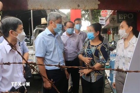 Thứ trưởng Bộ Y tế Nguyễn Trường Sơn thăm hỏi cán bộ địa phương tại hẻm 251, phường 10, quận Gò Vấp đang bị phong tỏa do có 2 ca mắc COVID-19. (Ảnh: Đinh Hằng/TTXVN) 