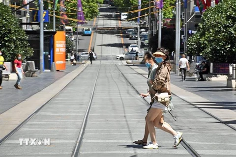 Người dân đeo khẩu trang phòng dịch COVID-19 khi di chuyển trên phố ở Melbourne, bang Victoria, Australia ngày 9/11/2020. (Nguồn: AFP/TTXVN) 