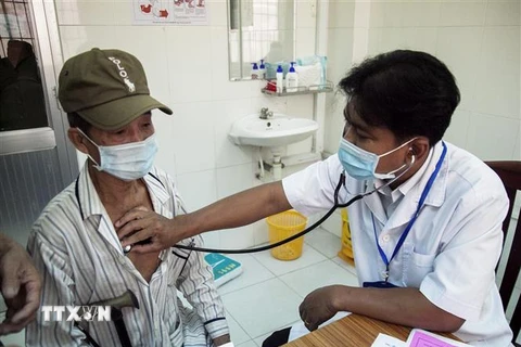 Bác sỹ Danh Ngọc Châu khám bệnh cho người dân tại Phòng khám Trung tâm Y tế huyện Châu Thành. (Ảnh: Hồng Đạt/TTXVN) 