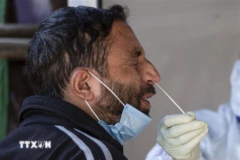 Nhân viên y tế lấy mẫu xét nghiệm COVID-19 cho người dân tại thành phố Srinagar, thủ phủ mùa hè của khu vực Kashmir do Ấn Độ kiểm soát, ngày 24/2/2021. (Nguồn: THX/TTXVN) 