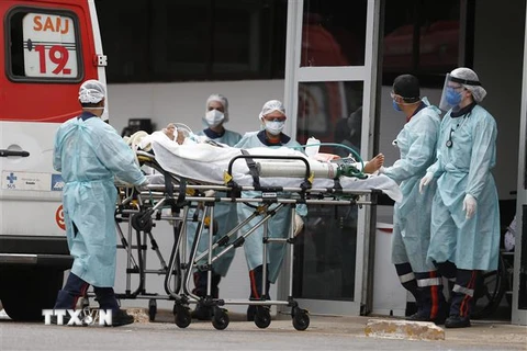 Nhân viên y tế chuyển bệnh nhân COVID-19 tới bệnh viện ở Brasilia, Brazil, ngày 11/3/2021. (Nguồn: THX/TTXVN) 