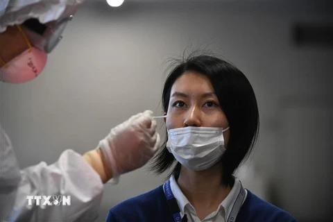 Nhân viên y tế lấy mẫu xét nghiệm COVID-19 tại Tokyo, Nhật Bản. (Nguồn: AFP/TTXVN) 