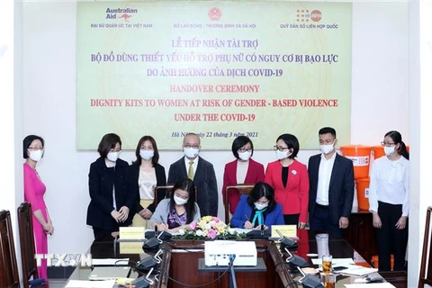 Bà Naomi Kitahara, Trưởng đại diện Quỹ Dân số Liên hợp quốc tại Việt Nam (bên trái) và Thứ trưởng Bộ Lao động- Thương binh và Xã hội Nguyễn Thị Hà (bên phải) ký bàn giao bộ đồ dùng thiết yếu hỗ trợ phụ nữ có nguy cơ bạo lực do ảnh hưởng của dịch COVID-19.