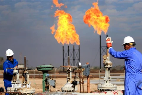 Công nhân làm việc tại một cơ sở khai thác dầu ở Basra, Iraq. (Nguồn: AFP/TTXVN) 