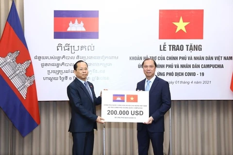 Thứ trưởng Ngoại giao Nguyễn Quốc Dũng trao tượng trưng cho Đại sứ Campuchia tại Việt Nam Chay Navuth khoản hỗ trợ 200.000 USD của Chính phủ và nhân dân Việt Nam. (Nguồn: Bộ Ngoại giao) 