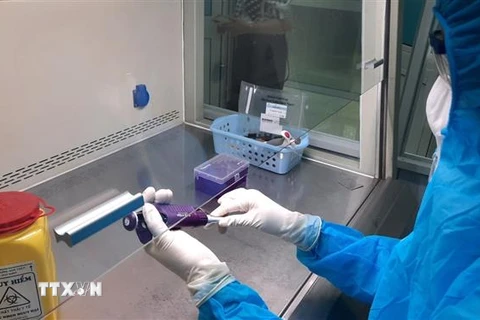Nhân viên y tế Bệnh viện Đa khoa tỉnh Vĩnh Long vận hành thử hệ thống xét nghiệm chẩn đoán COVID-19 bằng kỹ thuật Realtime PCR. (Ảnh: Lê Thúy Hằng/TTXVN) 