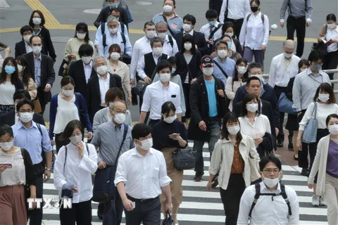 Người dân đeo khẩu trang phòng dịch COVID-19 khi di chuyển trên phố ở Tokyo, Nhật Bản. (Nguồn: AFP/TTXVN) 