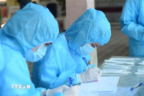 Nhân viên y tế lấy danh sách người đến xét nghiệm COVID-19 ở Đà Nẵng. (Ảnh: Văn Dũng/TTXVN) 