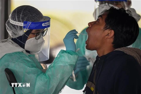 Nhân viên y tế lấy mẫu xét nghiệm COVID-19 cho người dân tại Kuala Lumpur, Malaysia. (Nguồn: AFP/TTXVN) 