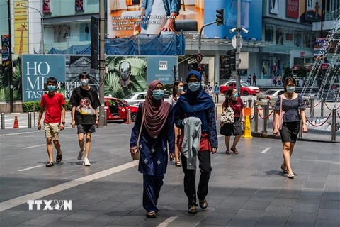 Người dân đeo khẩu trang phòng lây nhiễm COVID-19 tại Kuala Lumpur, Malaysia. (Nguồn: AFP/TTXVN) 