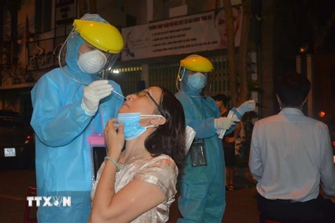 Nhân viên y tế quận Hải Châu khẩn trương lấy mẫu xét nghiệm người dân ngay trong đêm. (Ảnh: Văn Dũng/TTXVN) 