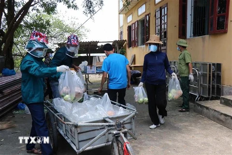 Các tình nguyện viên chuyển thực phẩm lên xe để đi phân phát cho các hộ dân tại xã Mão Điền. (Ảnh: Thanh Thương/ TTXVN) 