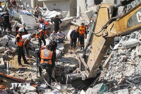 Lực lượng dân phòng Palestine tìm kiếm các nạn nhân dưới những căn nhà bị sập sau vụ không kích của máy bay Israel xuống thành phố Gaza, ngày 16/5/2021. (Nguồn: THX/TTXVN) 